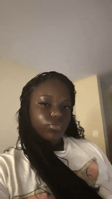 a woman wearing a white shirt with a peach on it