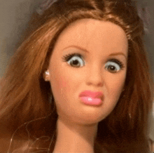 a close up of a doll making a funny face