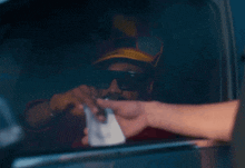a man wearing sunglasses and a hat is handing a receipt to another man