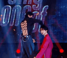 a man in a red jacket is kissing another man 's neck