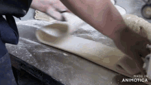 a person is kneading dough on a table and the words made in animotica are visible