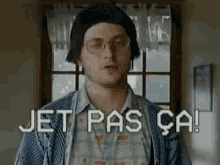 a man wearing glasses and a plaid shirt says jet pas ca !