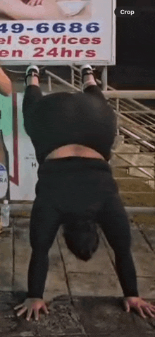 a man is doing a handstand in front of a sign that says ' crop ' .