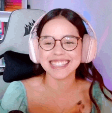 a woman wearing headphones and glasses is smiling
