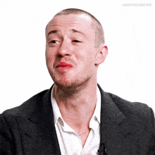 a man in a suit and white shirt is making a funny face josephquinngifs