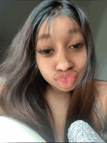 a woman with long hair is making a funny face with her lips