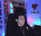 a man wearing headphones and a black shirt with the letter t on it is sitting in a chair