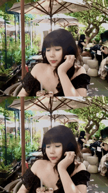 a woman in a black off the shoulder top sitting under an umbrella