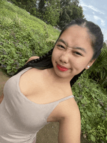 a woman taking a selfie in front of a grassy hill