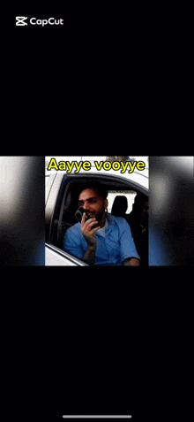 a man is sitting in the driver 's seat of a car talking on a phone .