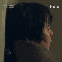 a poster for nine perfect strangers shows a woman behind a wall saying i want to go home