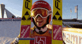 a person wearing a red helmet and goggles with the word uvex on the front