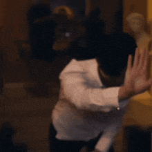 a blurry picture of a man in a white shirt and black pants
