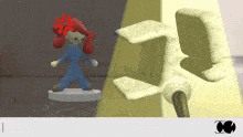 a cartoon character with a red angry face is standing next to a white object