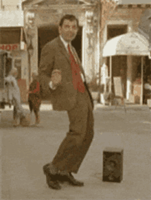 a man in a suit and tie is dancing on the street