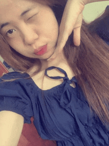 a woman taking a selfie with her hand on her chin