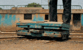 a person standing on a stack of blue boxes on the tracks