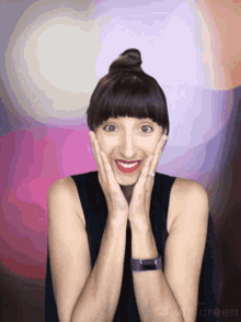 a woman is making a surprised face with her hands on her face in front of a purple background