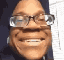 a close up of a person wearing glasses smiling .