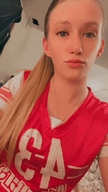 a girl is wearing a red jersey with the number 64 on it