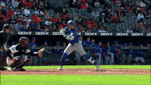 a baseball player swings his bat at a ball in front of a banner that says govx