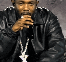 a man in a black leather jacket holds a microphone