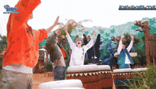 a group of people are dancing in front of a sign that says ' besty '
