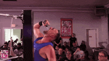 a man is drinking water from a bottle in front of a sign that says rad pro