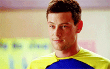 a man is wearing a yellow and blue shirt