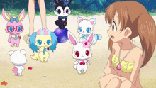 a girl in a bikini sits on the beach with a bunch of stuffed animals around her