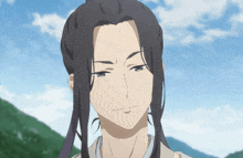 a man with long hair and a ponytail looks at the camera