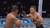 two men are fighting in a ring with a sign that says crypto.com in the background