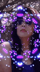 a woman wearing sunglasses with purple and blue lights around her face