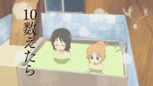 two girls are taking a bath in a bathtub with the number 10 on the bottom