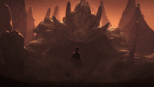 a man stands in front of a large rock formation in a dark cave