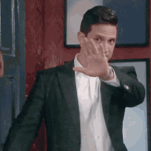 a man in a suit is making a stop sign