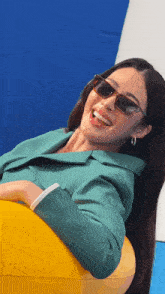 a woman wearing sunglasses and a green jacket is sitting on a yellow float