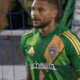 a man wearing a green and yellow jersey that says uchealth on the front