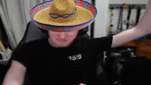 a man wearing a sombrero and a black shirt with the number 16:29 on it