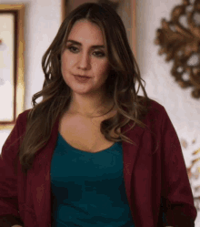 a woman wearing a blue top and a red jacket