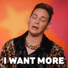 a man wearing a leopard print jacket and a gold chain around his neck says i want more