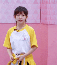 a girl wearing a yellow shirt that says producer 101 on it