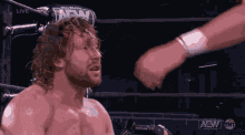 a man in a wrestling ring with the word aew on the back