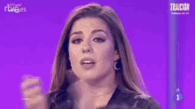 a woman is standing in front of a purple screen with the number 1 on it