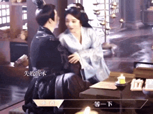a man and woman are sitting at a table with chinese writing on the bottom right
