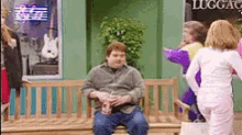 a man is sitting on a bench in front of a store that says luggage
