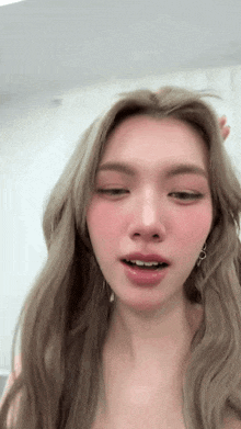 a close up of a woman 's face with blonde hair and pink cheeks