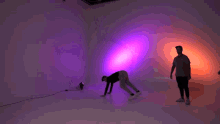a man is standing in front of a purple background .