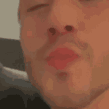 a close up of a man 's face with red lips .