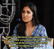a woman in a plaid shirt is talking about the music industry and our culture .